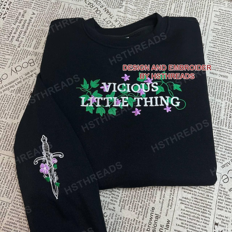 Pu&ograve; includere: Felpa nera a maniche lunghe con viti verdi e fiori viola ricamati. Il testo "VICIOUS LITTLE THING" &egrave; ricamato in verde e viola sul davanti della felpa. Il testo "DESIGN AND EMBROIDER BY HSTHREADS" &egrave; ricamato in rosso sul davanti della felpa.