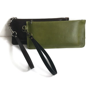 May include: Two leather pouches with black straps and silver clasps. One pouch is brown and the other is green.