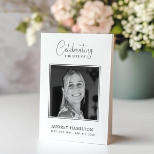 May include: A black and white photo memorial card with the text "Celebrating the life of" and a black and white photo of a woman. The text below the photo reads "Audrey Hamilton Sept. 21st, 1997 - Apr. 8th, 2025".