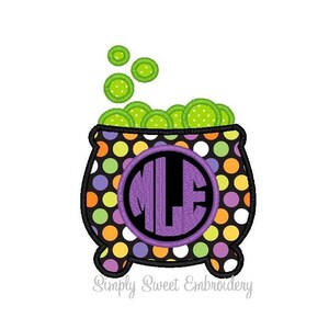 Puede incluir: Un caldero morado, negro y verde con un patrón de lunares y un monograma morado en el centro. El caldero está lleno de líquido verde burbujeante.