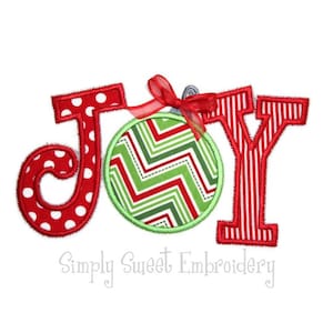 May include: Red, white, and green Christmas ornament with a red ribbon and the word "JOY" in red letters with white polka dots and red stripes.