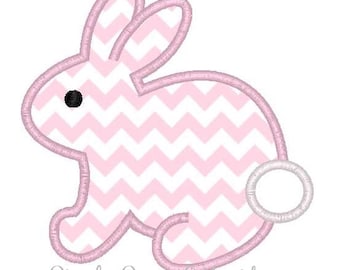 May include: Pink bunny embroidery design with a chevron pattern and a white circle for the tail.  The design is outlined in pink.