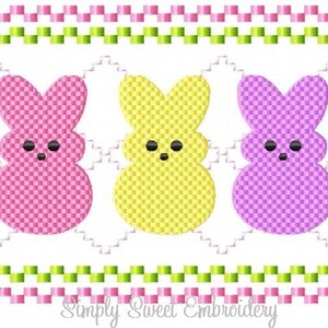 May include: Three embroidered Easter bunny shapes in pink, yellow, and purple. Each bunny has a checkered pattern and black eyes. The bunnies are framed by a green and pink checkered border.