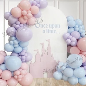May include: A pastel balloon arch in pink, lavender, and blue surrounds a white backdrop featuring a pink castle silhouette. The text "Once upon a time..." is displayed, with the words "Happy Party Time Us" in script.