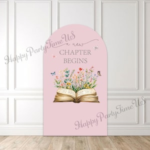 Puede incluir: Un letrero rosa en forma de arco con las palabras "a new CHAPTER BEGINS" y una ilustración de un libro abierto con flores y mariposas. El letrero está colocado contra una pared blanca.