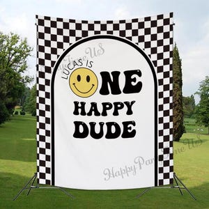 Könnte beinhalten: Ein weißer Hintergrund mit einem schwarz-weißen karierten Rand. Der Hintergrund hat einen großen weißen Kreis mit einem gelben Smiley und dem Text "Lucas is One Happy Dude".