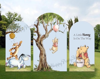 Puede incluir: Fondo de tres paneles con temática de Winnie the Pooh con ilustraciones de Pooh, Tigger y Eeyore. El telón de fondo presenta un árbol, una colmena y el texto "A Little Hunny Is On The Way". La combinación de colores incluye azul, marrón, amarillo y rosa.