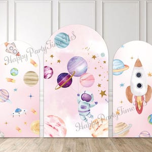 Peut inclure: Toile de fond à trois panneaux sur le thème de l'espace. Chaque panneau présente un fond rose avec des planètes, des étoiles et des fusées. Un panneau montre un astronaute tenant des ballons planétaires. Le texte "Happy Party Time" est écrit sur chaque panneau.