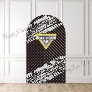 Könnte beinhalten: Ein schwarzer und silberner bogenförmiger Hintergrund mit Reifenspuren und dem Text "DEAN'S 3RD JAM!" in einem gelben Dreieck. Der Hintergrund hat ein Riffelblechmuster.