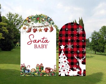 May include: Two Christmas-themed arch-shaped signs. One has the text "Santa BABY" with festive illustrations. The other has a red and black plaid pattern with a Christmas tree, snowflakes, and deer silhouettes.