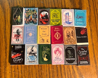 Puede incluir: Una colección de dieciocho libros en miniatura dispuestos en una cuadrícula, que presentan títulos clásicos como The Great Gatsby, Dracula, Treasure Island, Black Beauty, Alice's Adventures in Wonderland, Winnie the Pooh, Pride and Prejudice y Frankenstein.