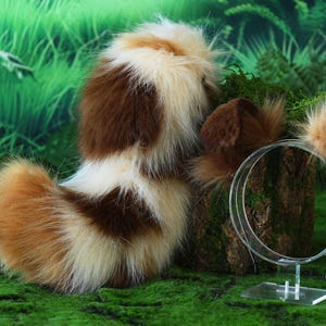 以下が含まれることがあります： ふわふわの茶色と白のコスチュームテールと、透明なヘッドバンドに合わせた耳。 テールは茶色、白、タンのフェイクファーのミックスです。 耳はタンと茶色です。