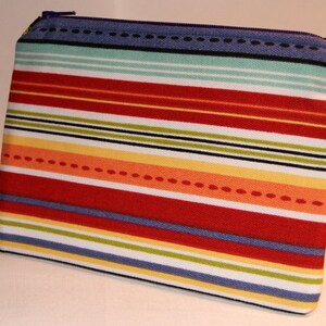 May include: A striped zippered pouch with a colorful design. The pouch has red, yellow, orange, blue, green, and white stripes.