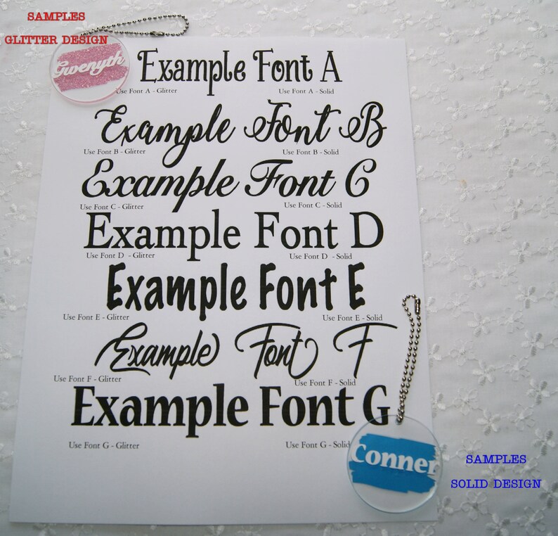 May include: A white sheet of paper with seven different font styles displayed in black. Each font style is labeled with a letter from A to G. The text "SAMPLES GLITTER DESIGN" is at the top of the page. The text "SAMPLES SOLID DESIGN" is at the bottom of the page.
