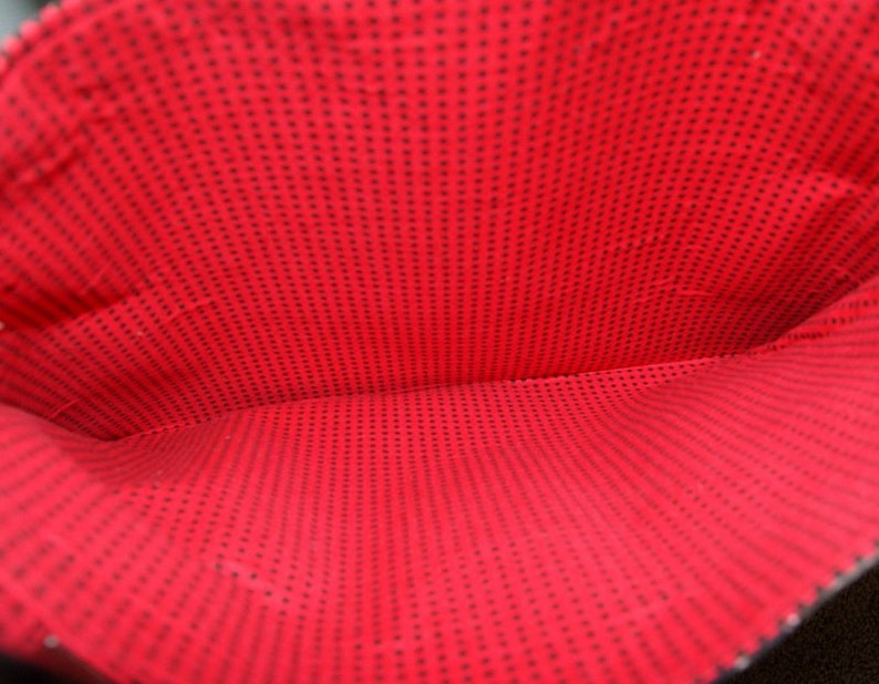 May include: The inside of a red bag with a black polka dot pattern.