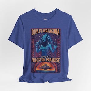 May include: Blue t-shirt featuring a retro concert poster design. The graphic includes the text "DIVA PLAVALAGUNA LIVE AT FHLOSON PARADISE" with an illustration of a blue alien-like figure holding a microphone.