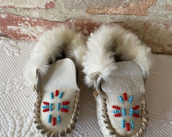 Sällsynta barnmockasiner från 1930-talet. Handpärlade läderskor i indiansk stil med pälskant.