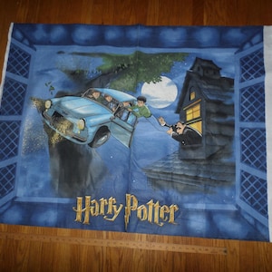 May include: A blue fabric panel featuring a scene from Harry Potter. A light blue car is flying through the air, with characters inside. A man is looking out of a window. The words "Harry Potter" are in gold lettering.