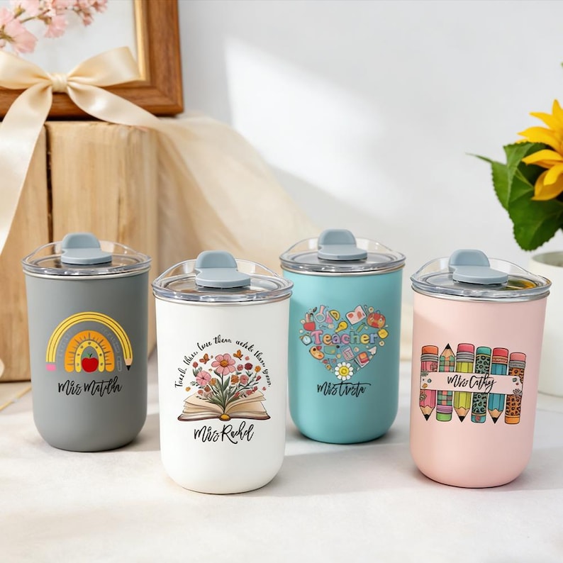 Pu&ograve; includere: Quattro bicchieri in acciaio inossidabile con coperchi trasparenti e chiusure a ribalta grigie. Ogni bicchiere presenta un design unico: un arcobaleno, un libro aperto con fiori, un cuore con la parola "Teacher" e matite. Ogni bicchiere ha il nome di un insegnante.