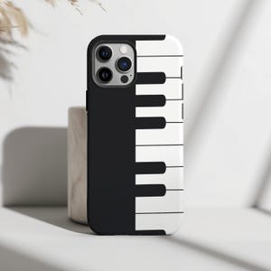 May include: Black and white phone case with a piano keyboard design. The case has a black background with white keys and black keys.