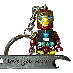 May include: Iron Man-themed keyring featuring a Lego-style figure with a gold and red helmet. The keyring includes a bottle opener and a metal tag with the inscription "I love you 3000".