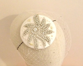 May include: White bridal hair comb with a large, sparkly, white flower design. The comb is on a white mannequin head.