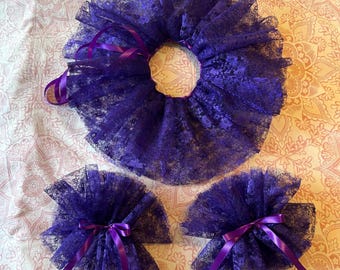 May include: A set consisting of one large circular purple lace ruffle collar and two smaller matching purple lace ruffle cuffs. Each piece is constructed from gathered purple lace fabric and features a thin purple satin ribbon tie.