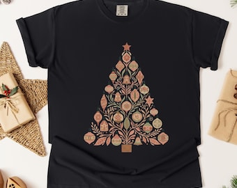Puede incluir: Camiseta negra con un diseño de árbol de Navidad. El árbol está compuesto por adornos rosas, verdes y dorados. La palabra "Black" está impresa en la parte superior. Una prenda festiva para la temporada navideña.