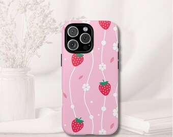 May include: Pink phone case featuring a repeating pattern of red strawberries, white flowers, and small pink leaves. The design is set against a light pink background. The case has a black camera module.