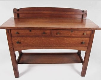 May include: A dark brown wooden sideboard with three drawers and a lower shelf. The sideboard has a curved top and decorative hardware.