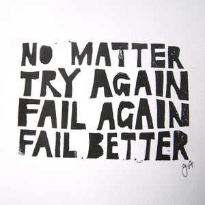 Op de afbeelding: Zwart-witte typografieprint met de tekst "No matter try again fail again fail better".