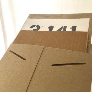May include: A brown cardboard envelope with a white paper insert. The insert has the number "2141" printed on it.