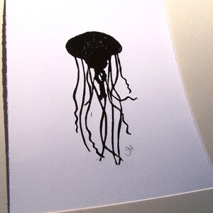 May include: A black and white illustration of a jellyfish. The jellyfish is depicted with a rounded bell and long, flowing tentacles. The artwork is signed with the initials "GA" in the lower right corner. The image is on a white background.