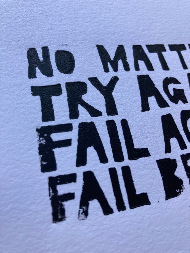 Op de afbeelding: Zwart-witte tekstafdruk op een witte achtergrond. De tekst luidt "No matter try again fail again fail better."