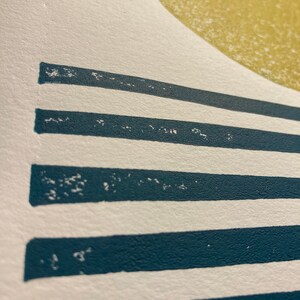 May include: A white background with a large yellow circle at the top and five horizontal teal blue stripes below the circle.