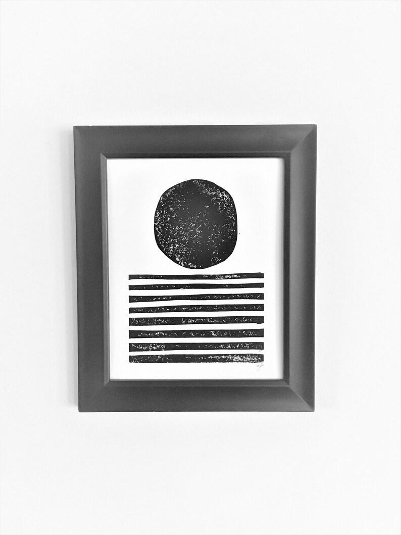 May include: Black and white abstract print of a circle and horizontal lines in a black frame.