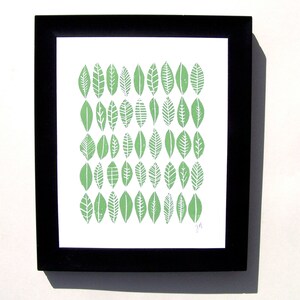 May include: A framed print with a pattern of green leaves in a black frame.