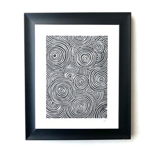 Könnte beinhalten: Schwarz-weiß gerahmter Druck eines abstrakten Designs mit konzentrischen Kreisen.