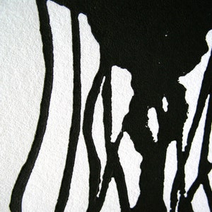 May include: Abstract black ink art on white paper. The image features thick, flowing black lines and shapes against a stark white background. The ink appears to have been applied with a brush or similar tool, creating a textured effect.