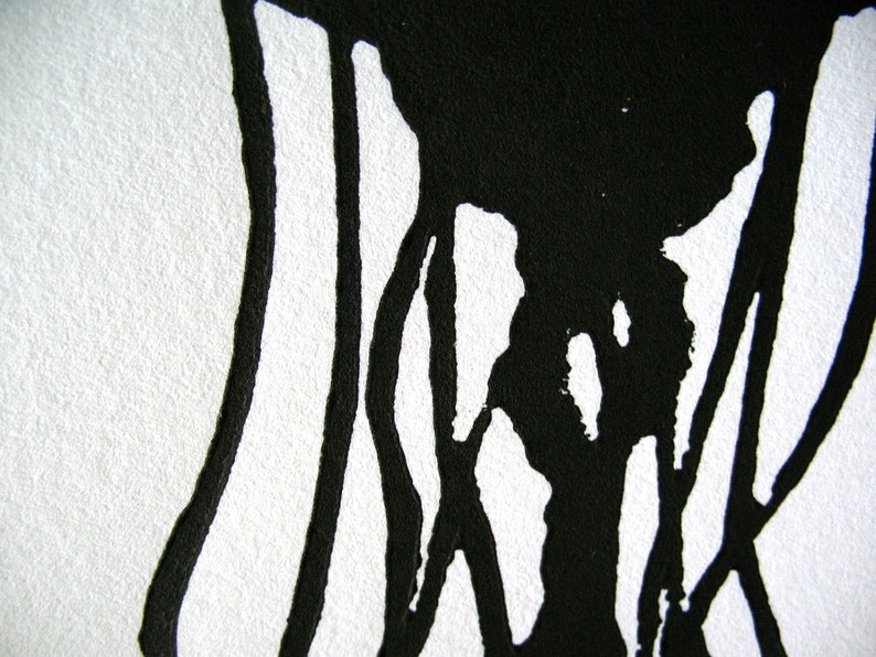 May include: Abstract black ink art on white paper. The image features thick, flowing black lines and shapes against a stark white background. The ink appears to have been applied with a brush or similar tool, creating a textured effect.