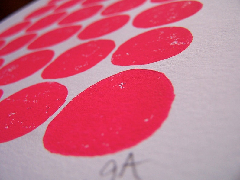 May include: A close-up of a white surface with a pattern of pink circles. The circles are arranged in a staggered pattern, with the larger circles in the center and the smaller circles around the edges.