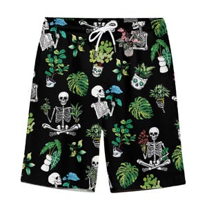 May include: Black swim trunks with a repeating pattern of skeletons holding potted plants. The plants are various shades of green and have white flowers.