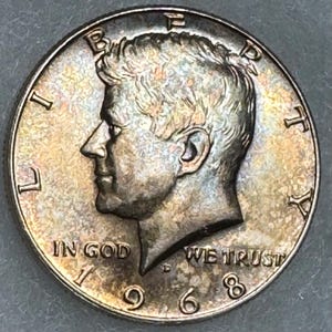 1968 D 40% Silver Kennedy Half Dollar featuring beautiful golden toning with shades of blue and coral tones. JFK 50 cent piece.