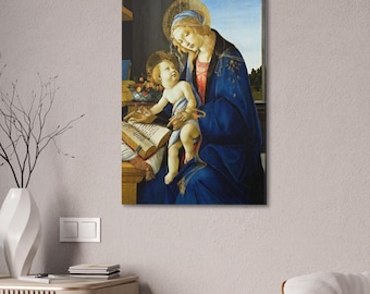 May include: A canvas print of a Renaissance-style painting. The artwork depicts a woman in a blue robe with a halo, holding a baby. The baby is reaching towards an open book on a wooden table. A window with a landscape view is in the background.