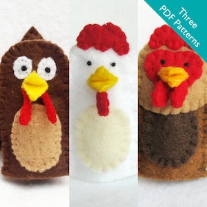 May include: Three felt finger puppets of chickens. The puppets are brown, white, and brown with red accents. The puppets have yellow beaks and black eyes. The puppets are for children to use for play and storytelling.