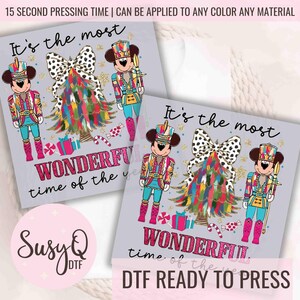 May include: It's the most wonderful time of the year! A Christmas-themed iron-on transfer featuring Mickey Mouse dressed as a nutcracker, a colorful Christmas tree, and the text "It's the most wonderful time of the year".