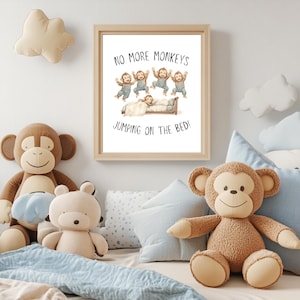 May include: A framed nursery print with a white background and black text that reads "No More Monkeys Jumping On The Bed!"  Five cartoon monkeys in blue overalls are jumping on a bed with a sleeping child in it.