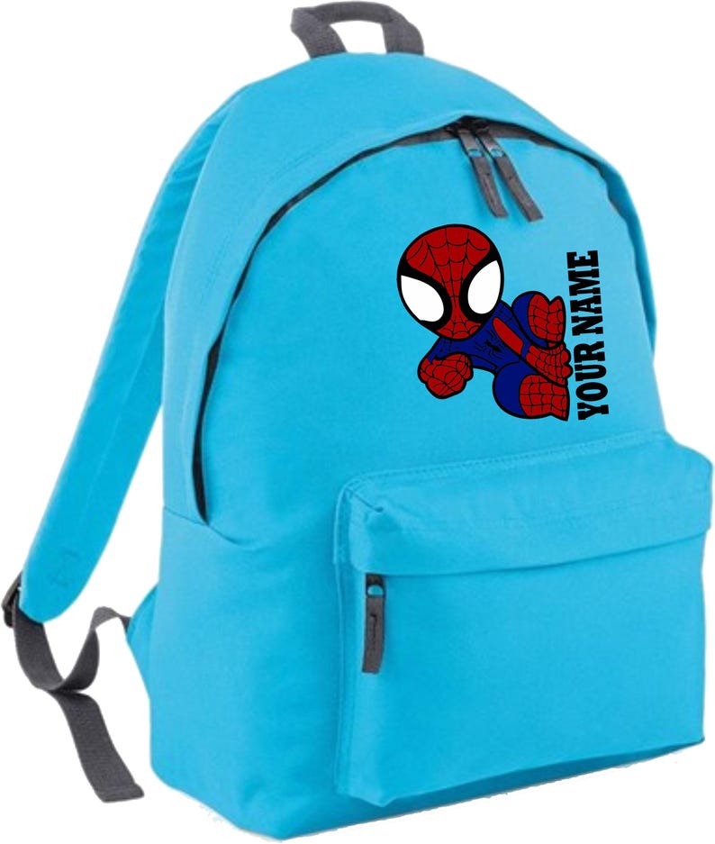 May include: A light blue backpack featuring a graphic of Spider-Man in red and blue. The backpack has a front pocket and two zippered compartments. The text "YOUR NAME" is printed vertically on the side.