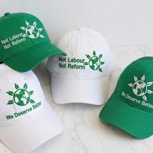 May include: Four baseball caps, two in green and two in white, are shown. Each cap has a globe design with text. The green caps read "Not Labour Not Reform" and "We Deserve Better." The white caps also display the same text.