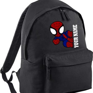 May include: Black backpack featuring a colorful cartoon Spider-Man graphic. The superhero is depicted in red and blue, with the text "YOUR NAME" printed vertically in white on the side. The backpack has a front pocket and two zippered compartments.
